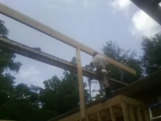 Carpenter setting a ridge beam over a new addition frame — Ice Dam Removal by Roofing Brothers in Frenchtown